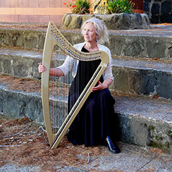 Auckland harp player and singer Robyn Sutherland with her electric harp outdoors on the steps